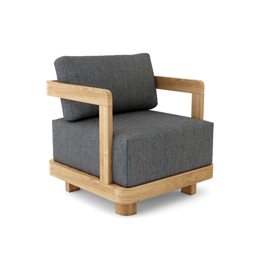A modern sleek Granada Deep Seating Armchair with a gray cushion made of sunbrella fabric, solid teak wood frame, and a throw pillow.