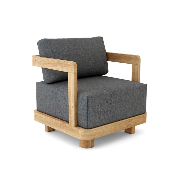 A modern sleek Granada Deep Seating Armchair with a gray cushion made of sunbrella fabric, solid teak wood frame, and a throw pillow.